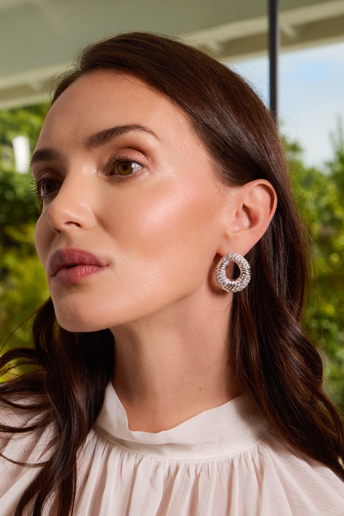 Model wearing silver Halle open hoop earring set with pavé CZ in white top.