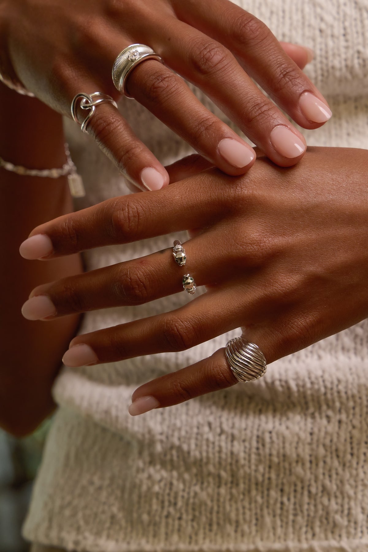 Model wearing silver panther ring paired with etta, ann marie and celine rings, styled with a cream knit top.