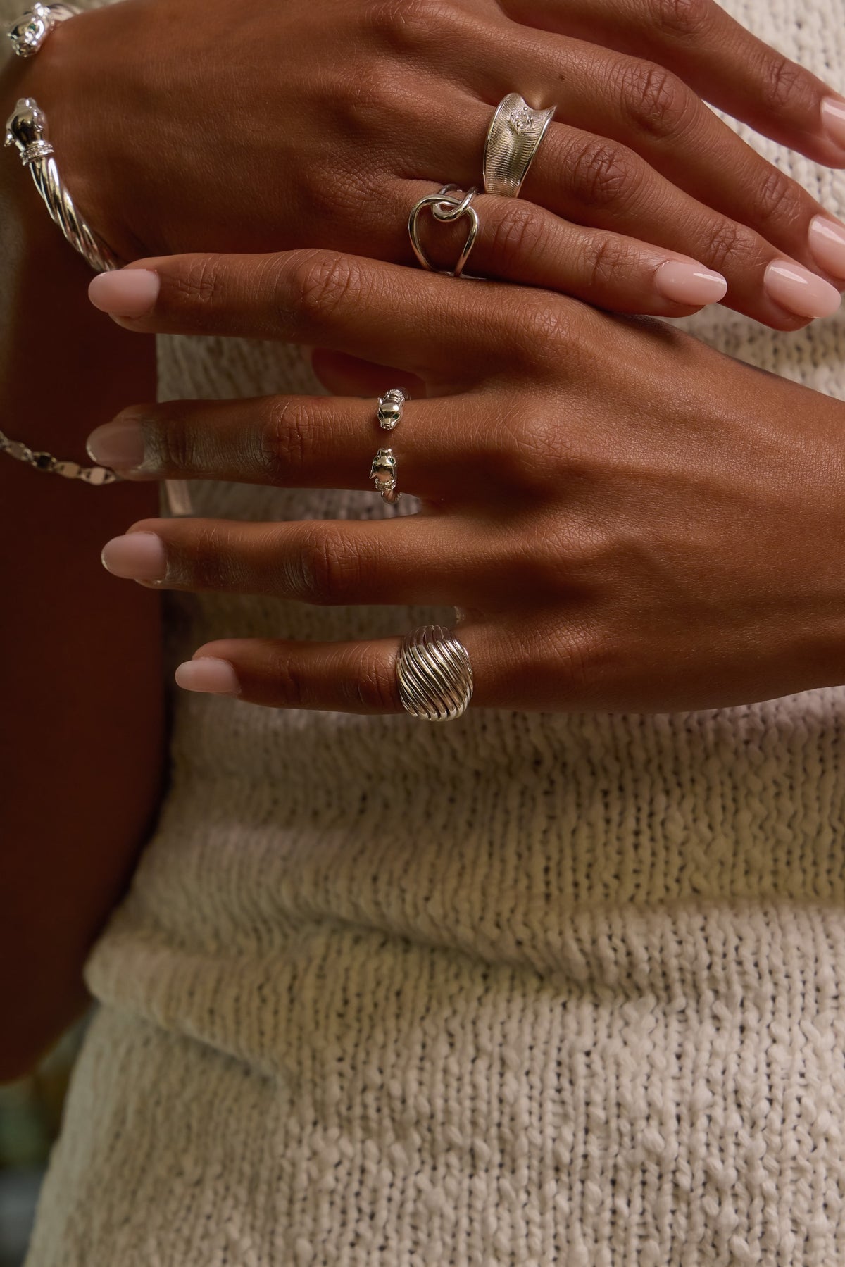 Model wearing silver etta dome ring paired with panther, celine and ann marie rings.