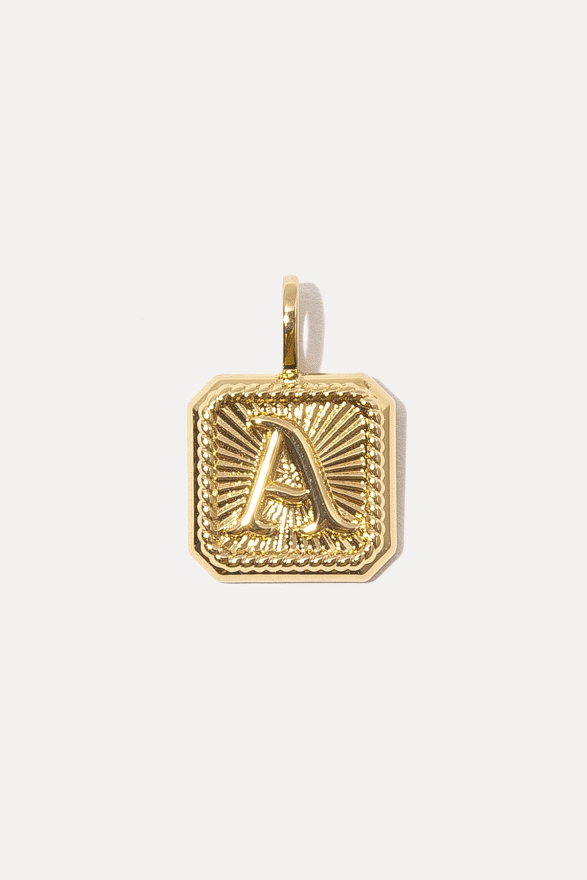 Gold octagonal Alpha Charm with a raised letter "A" and sunburst texture on a white background.