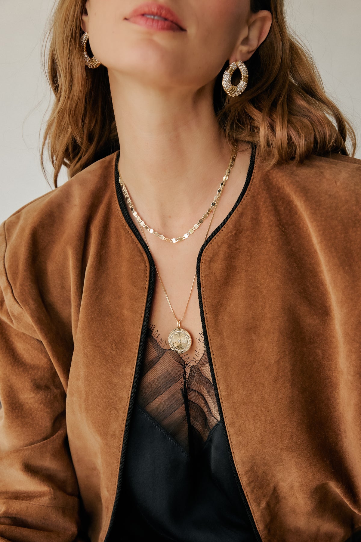 Model wearing gold Halle hoop earrings, Ava necklace, and Solara Charm pendant on josephine chain.