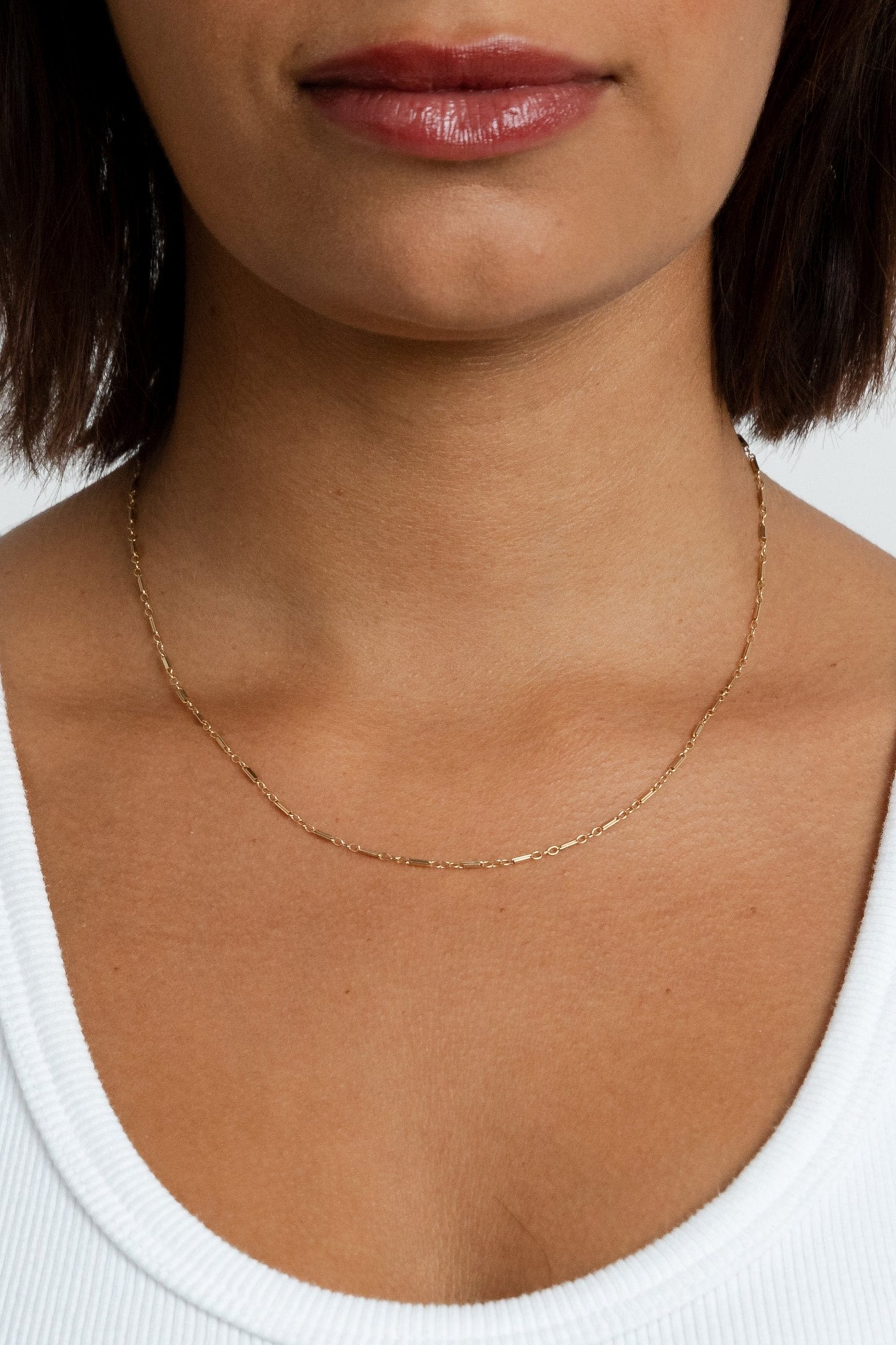 Close-up of a model wearing the gold Lindsey Chain necklace near her collarbone.