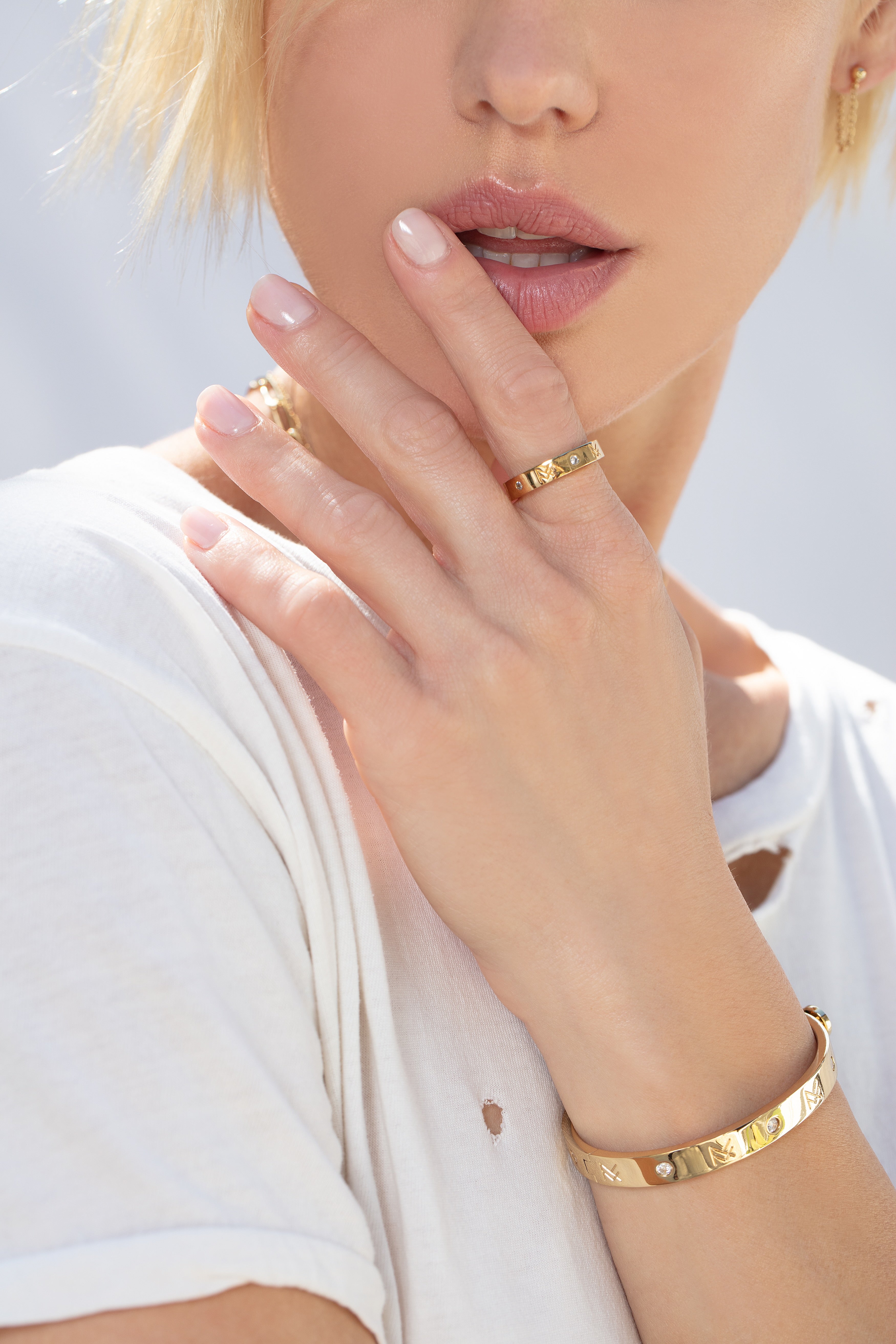 Model wearing the gold MF cuff and MF ring next to her white T-shirt.