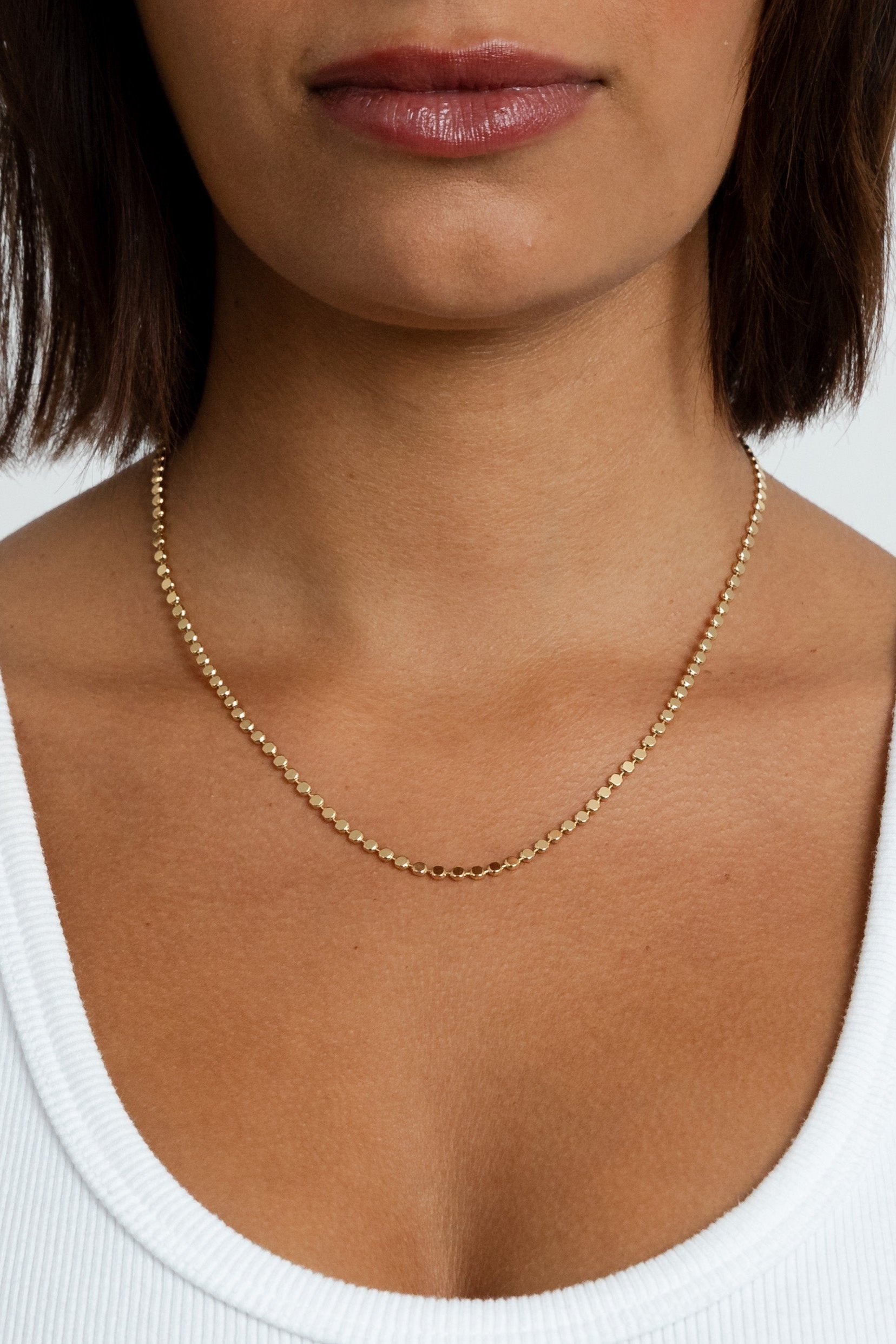 Model showcasing the layered look of the Paisley Gold Mirror Chain Necklace