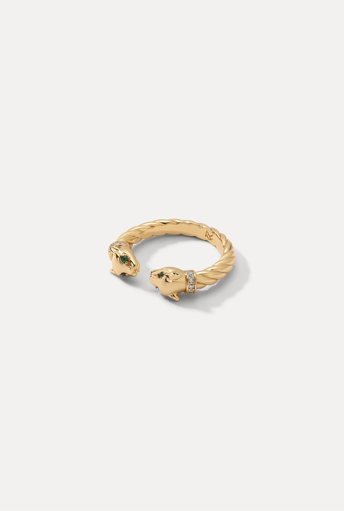 Gold open Panther Ring with twisted rope detail and green gemstone eyes on white backdrop.