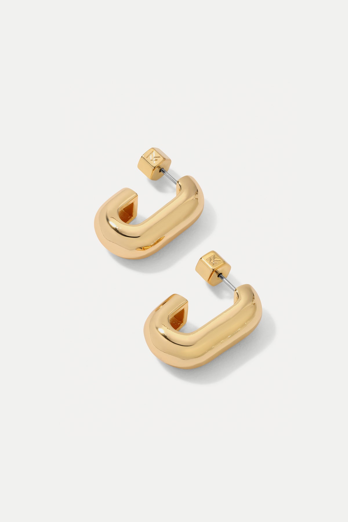 Gold Ellie huggie hoop earrings with smooth contoured edges on a plain white background.