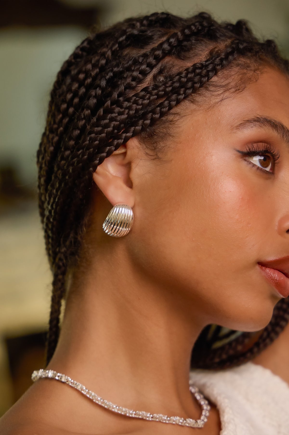 Model wearing silver Florence ribbed hoop earring paired with silver delilah necklace