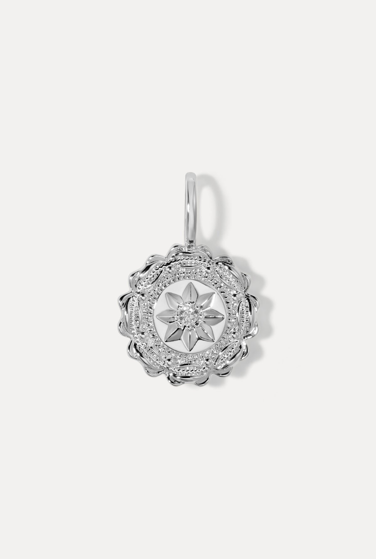 Silver Fleur Charm featuring a textured antique medallion design with a center CZ on a white background.