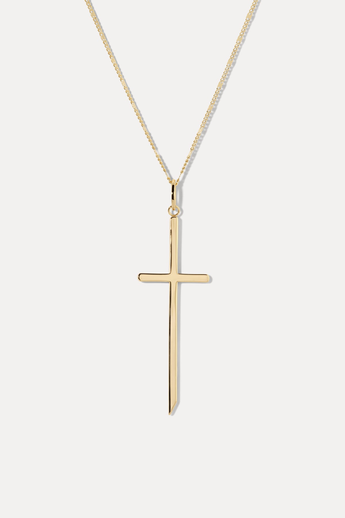 Gold cross pendant attached to a gold chain necklace displayed against a plain white background.