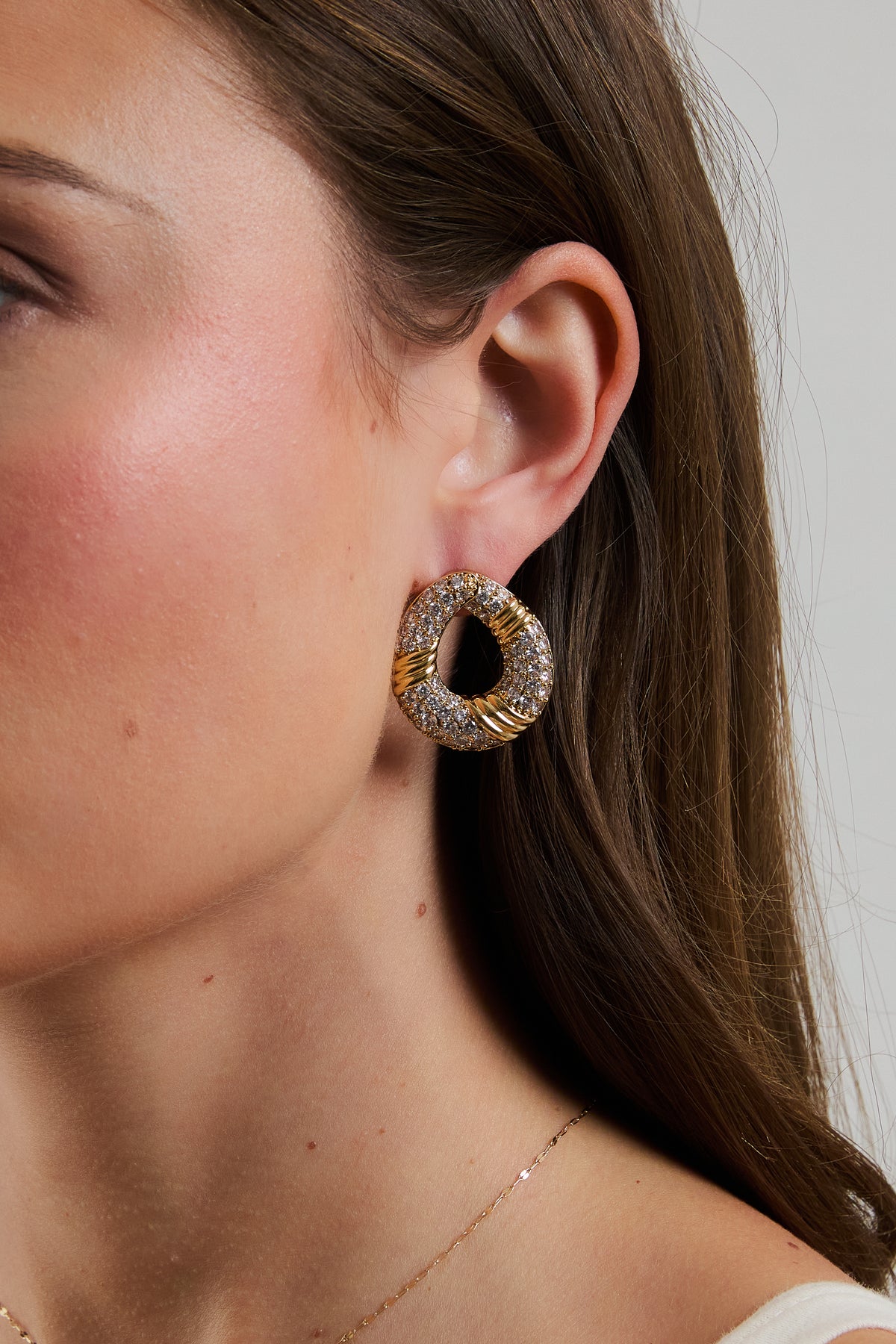 Model wearing gold Halle hoop earring with pavé CZ accents.