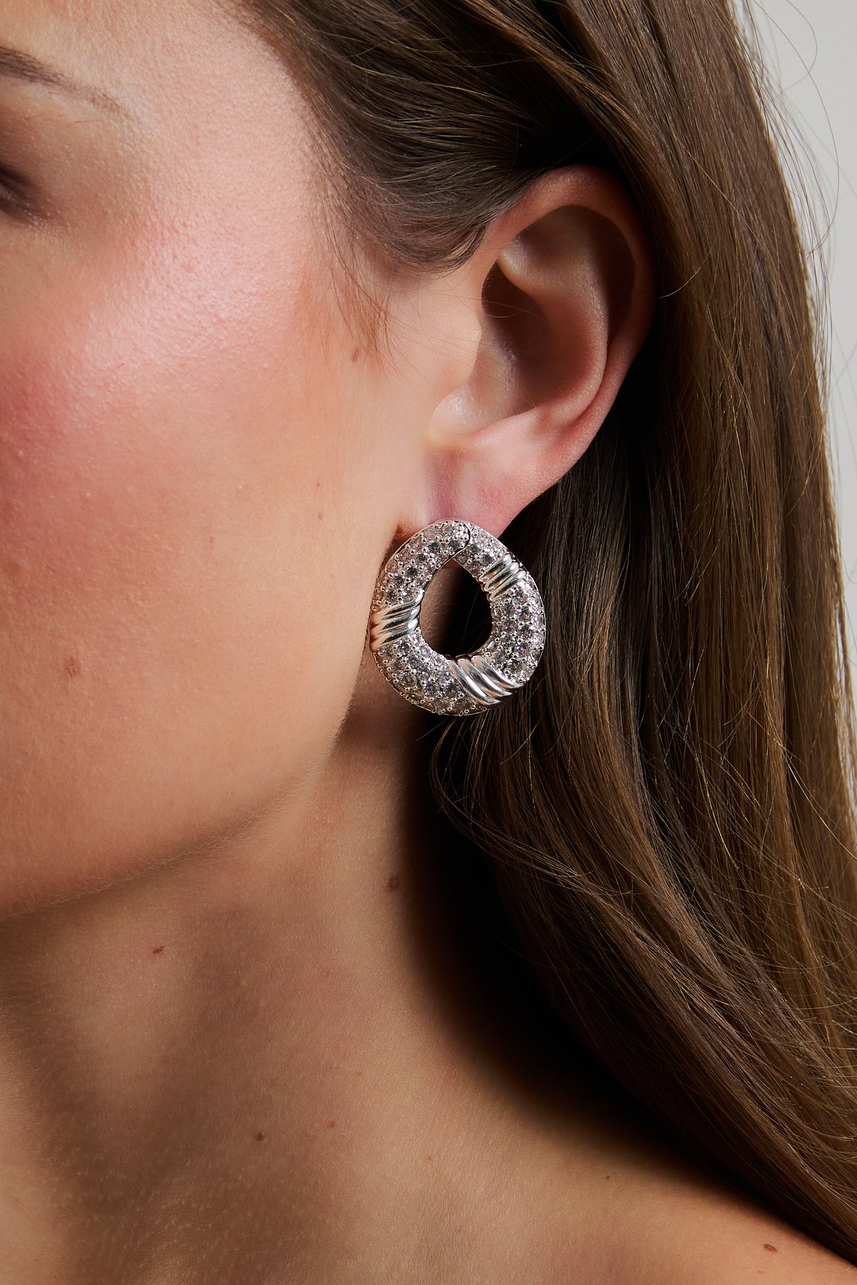 Model wearing silver Halle hoop earring with pavé CZ accents.