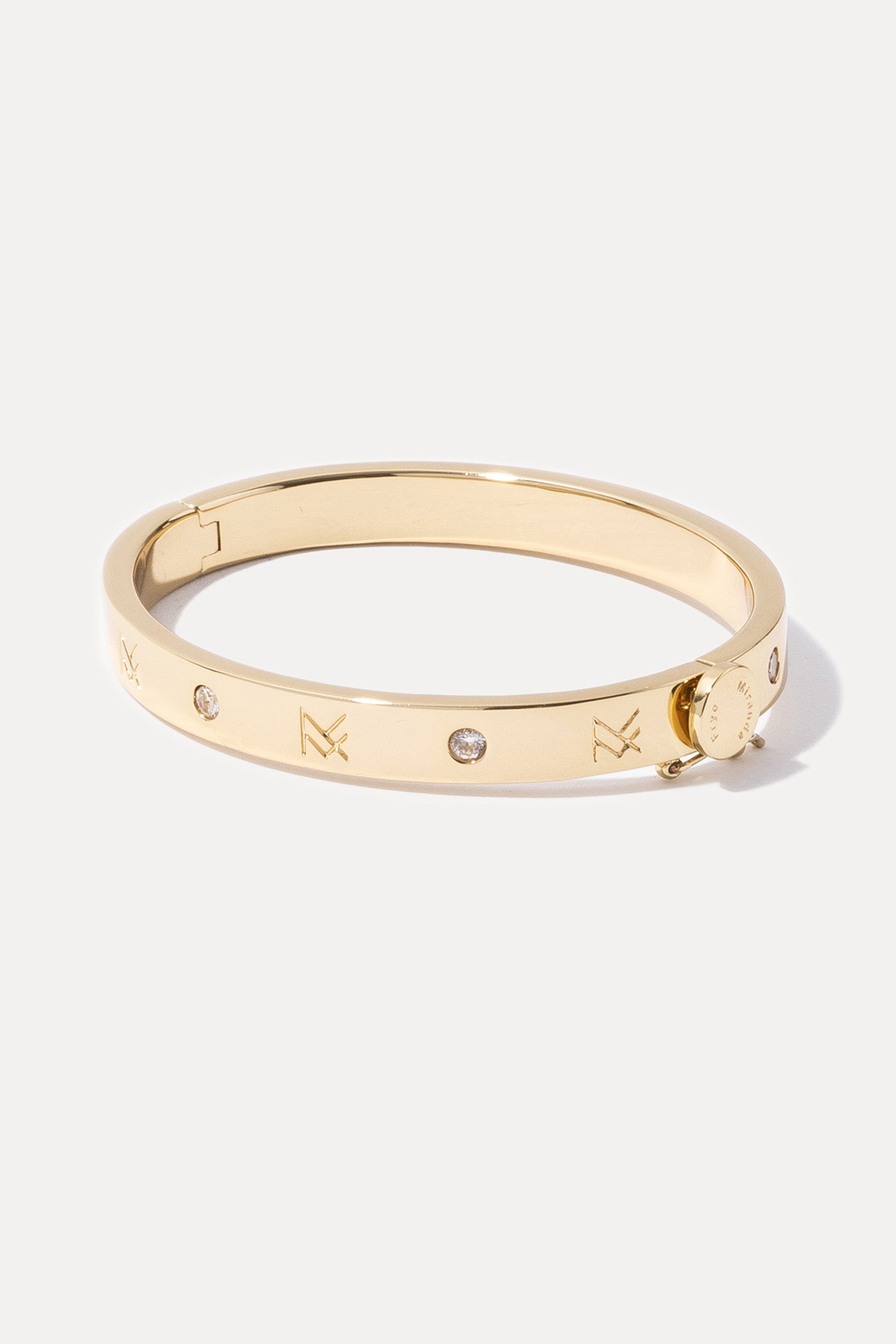 Gold MF Cuff featuring engraved logos and scattered mini CZ stones on a plain white background.