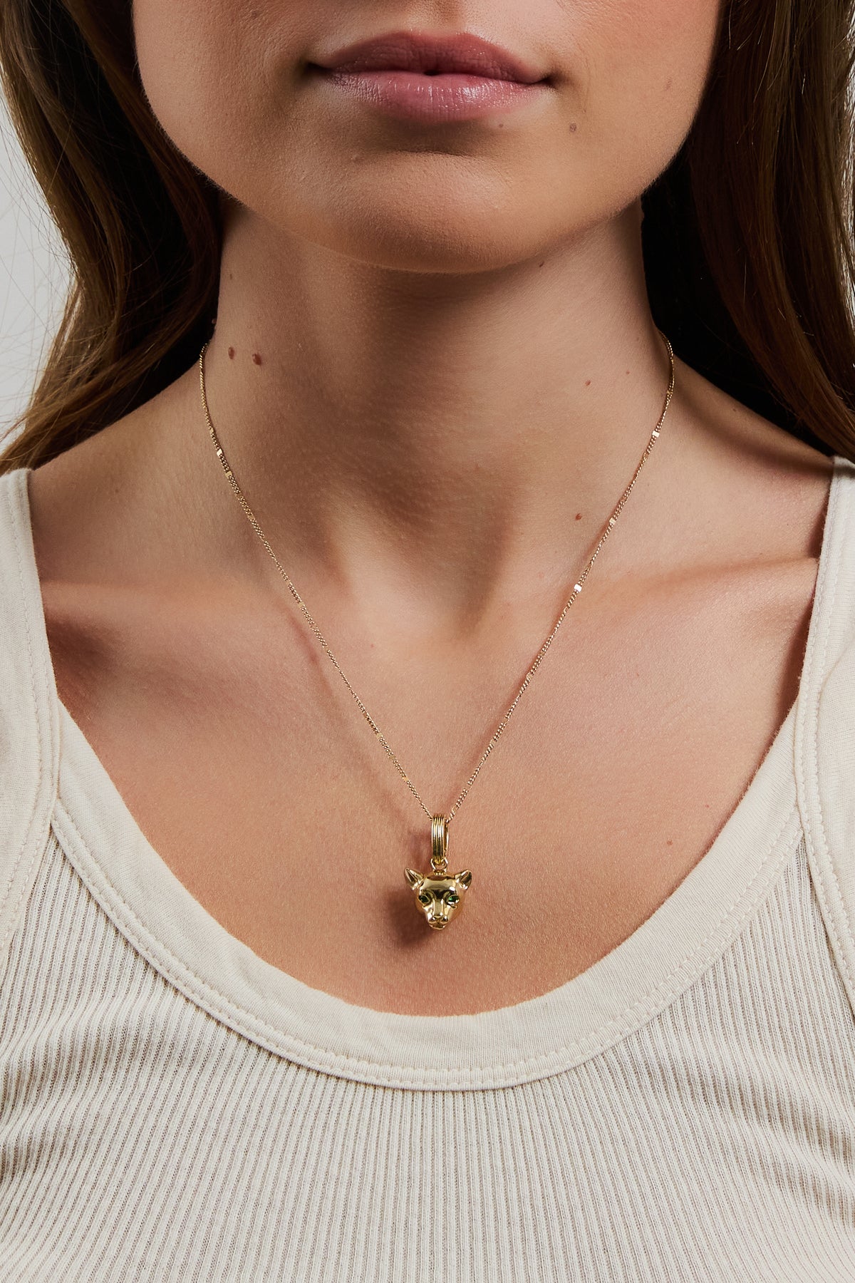 Model wearing gold Panther Charm on coco chain, styled with a cream ribbed tank top.