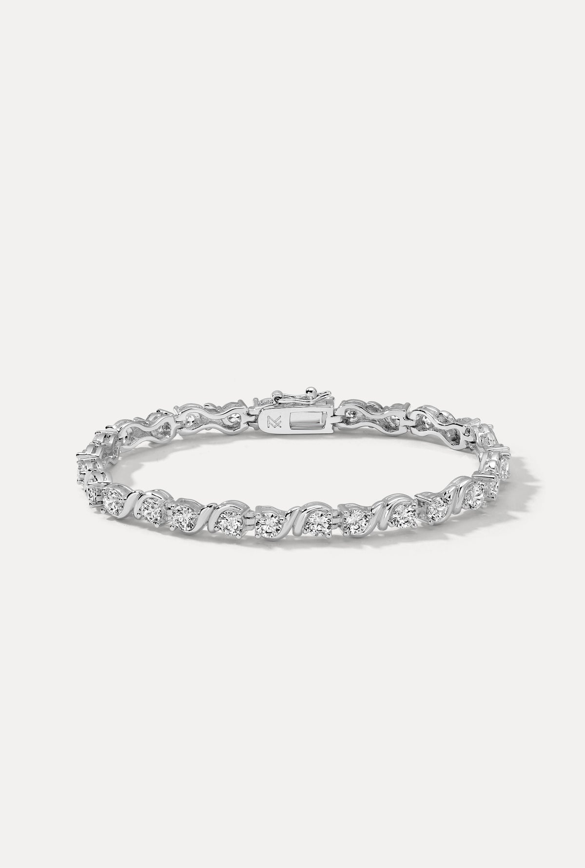 Silver Delilah tennis bracelet featuring round CZ stones in S-link wave settings on a white background.