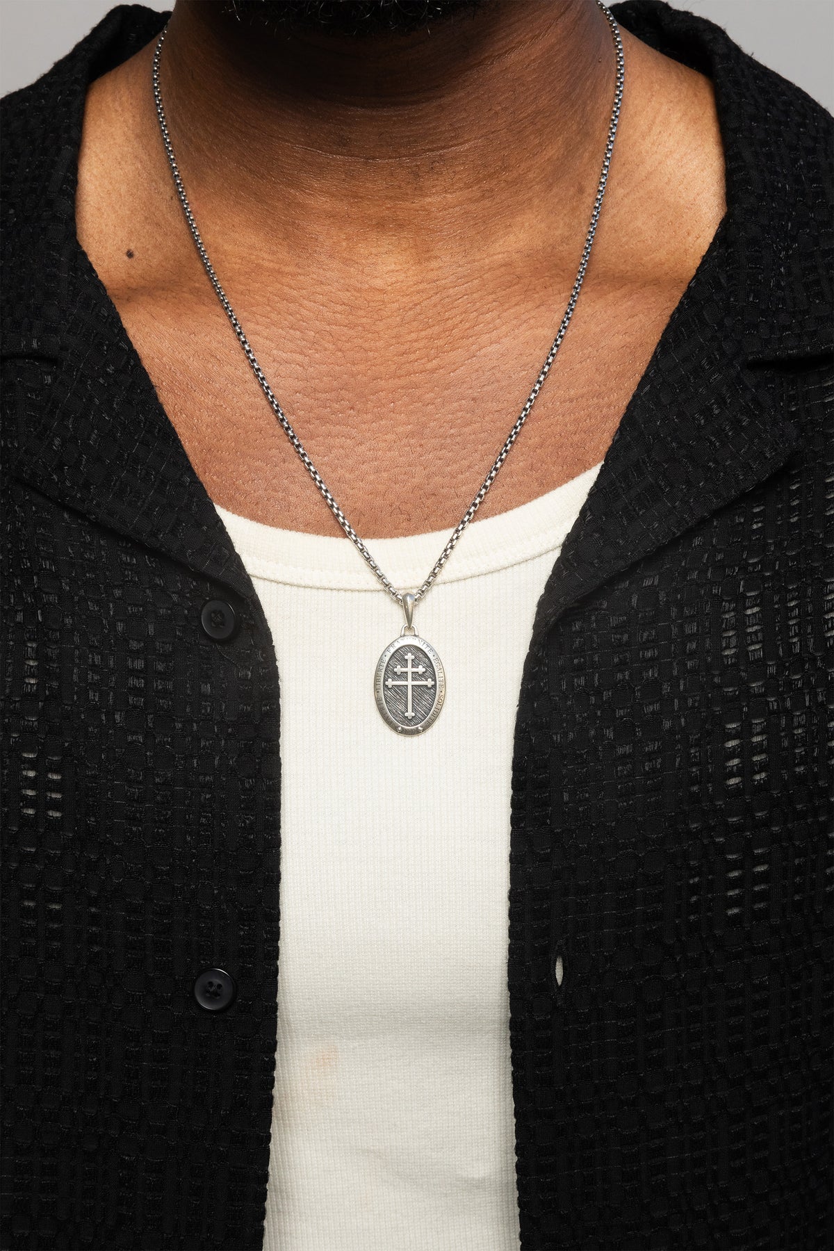 Male model showcasing the freedom pendant in sterling silver paired with the dylan chain.