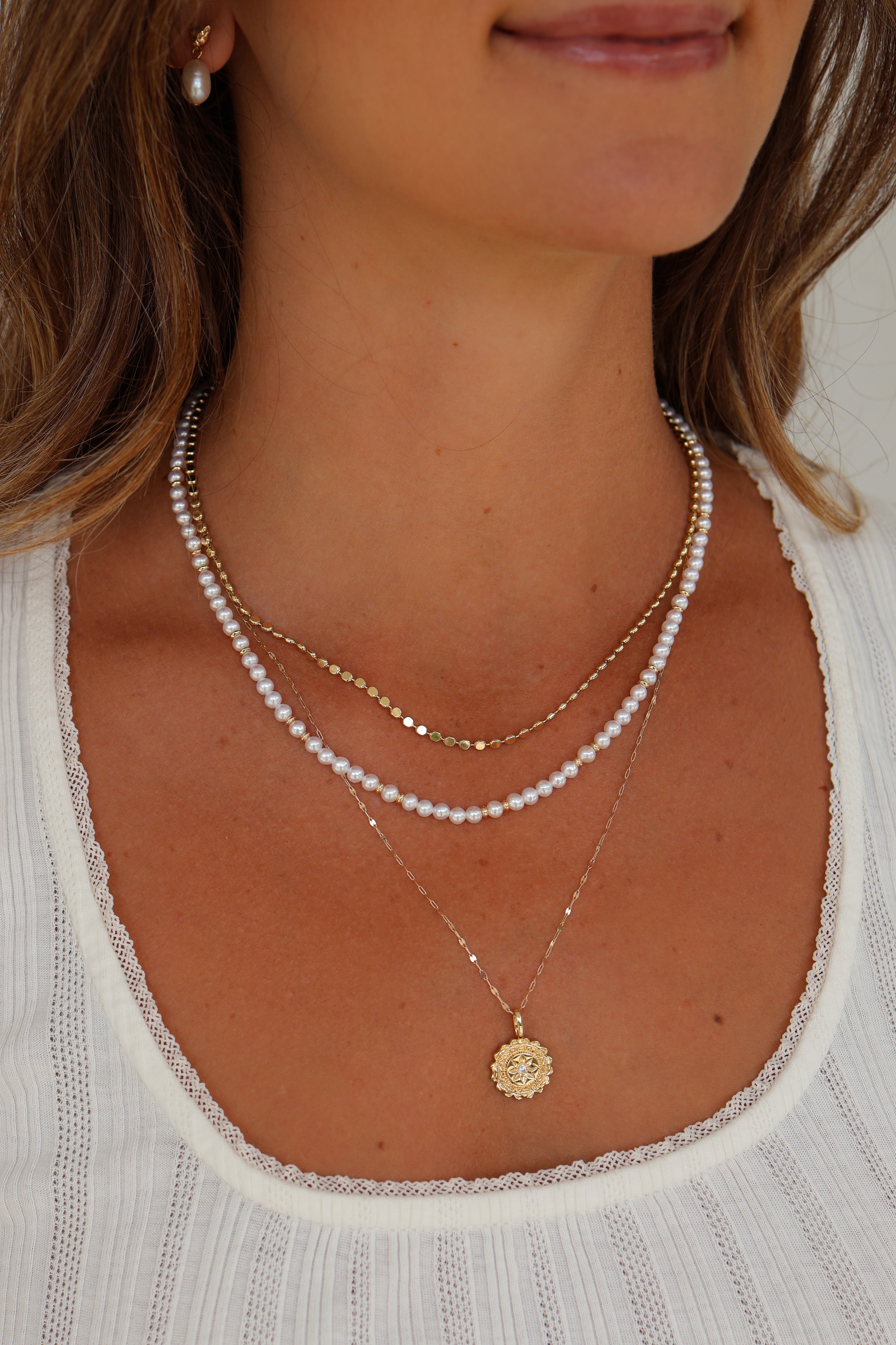 Model wearing layered gold necklaces featuring the Paisley Gold Mirror Chain Necklace