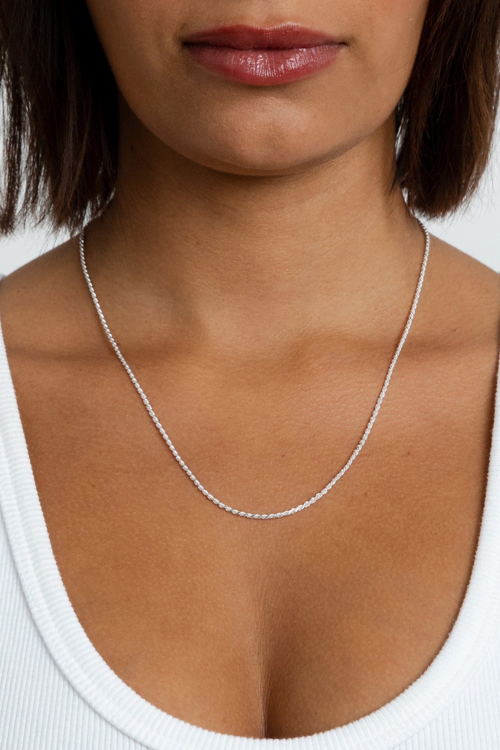 Model showcasing the silver Kate Chain rope necklace resting lower on her neckline.