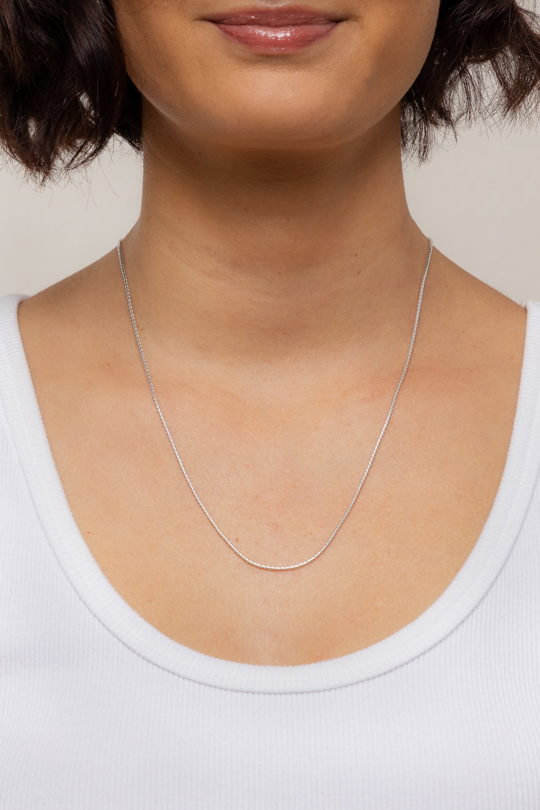 Model showcasing the sterling silver Mina Chain necklace resting lower on her neckline.