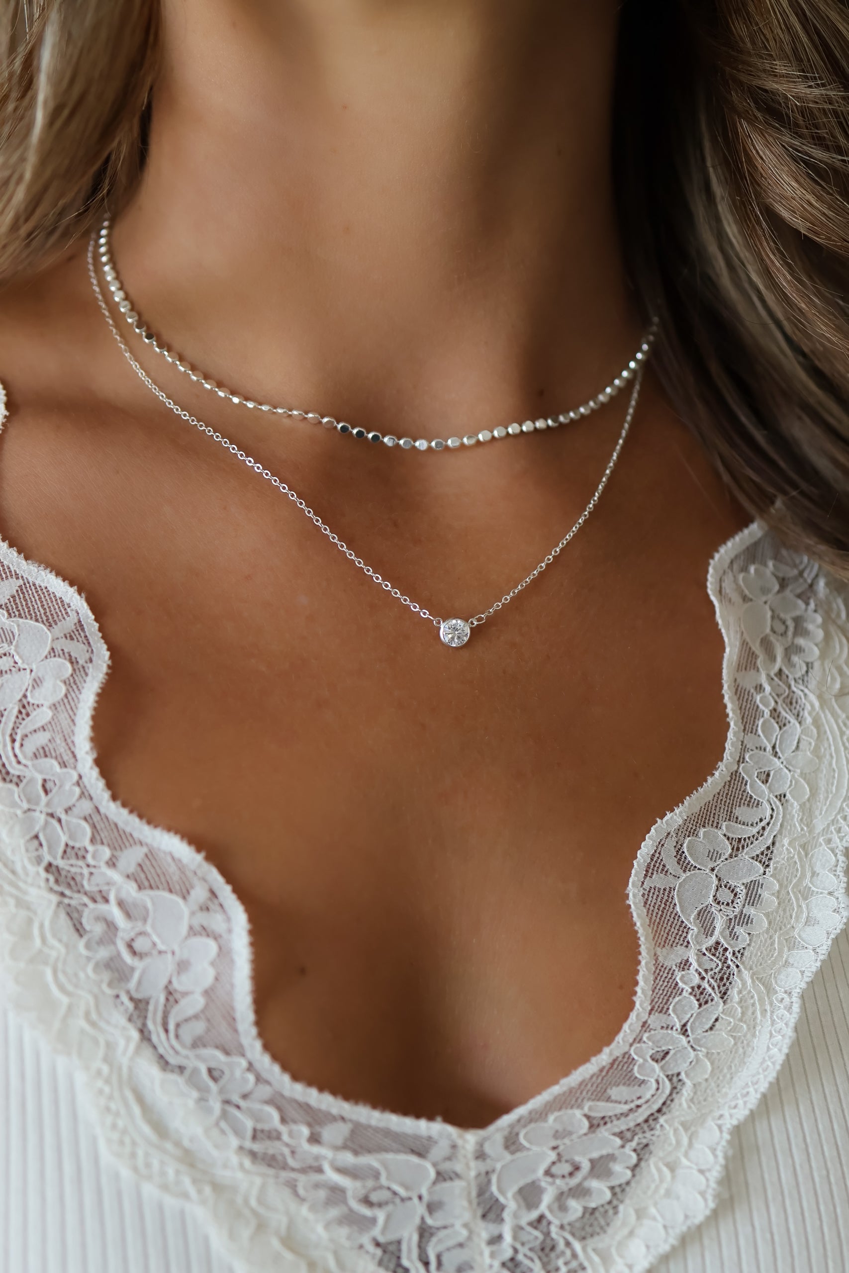 Model wearing the Paisley Silver Mirror Chain Necklace paired with the Silver Stephanie Necklace