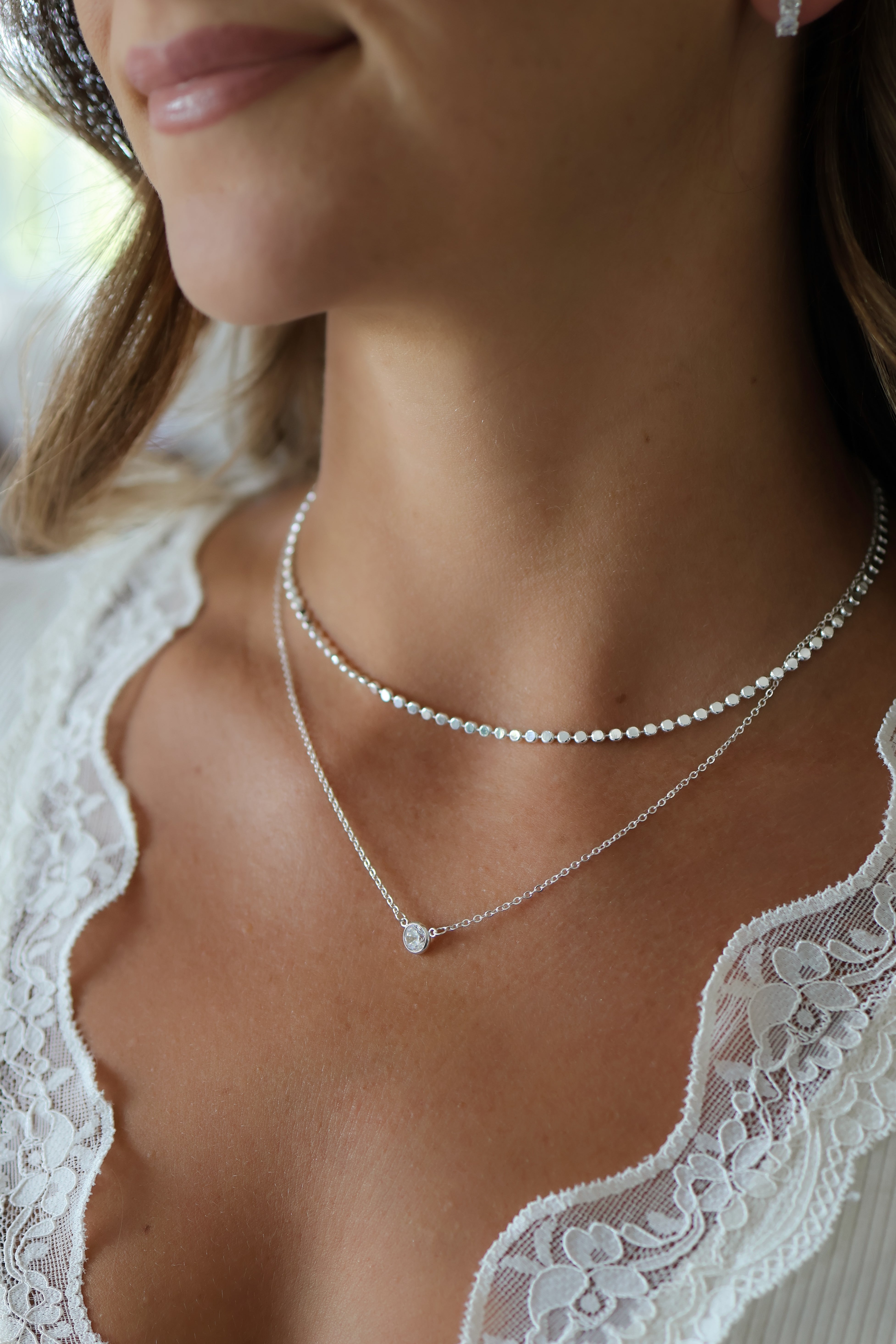 Close-up view of Paisley Silver Mirror Chain Necklace and Silver Stephanie Necklace on model